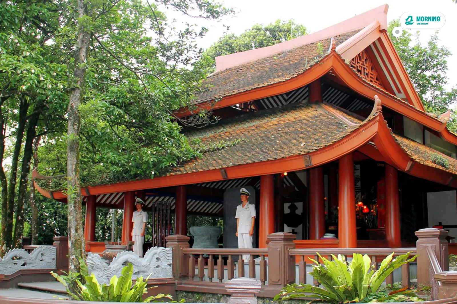 Ho Chi Minh Stilt House (Nhà sàn) — traditional red wooden architecture with guards